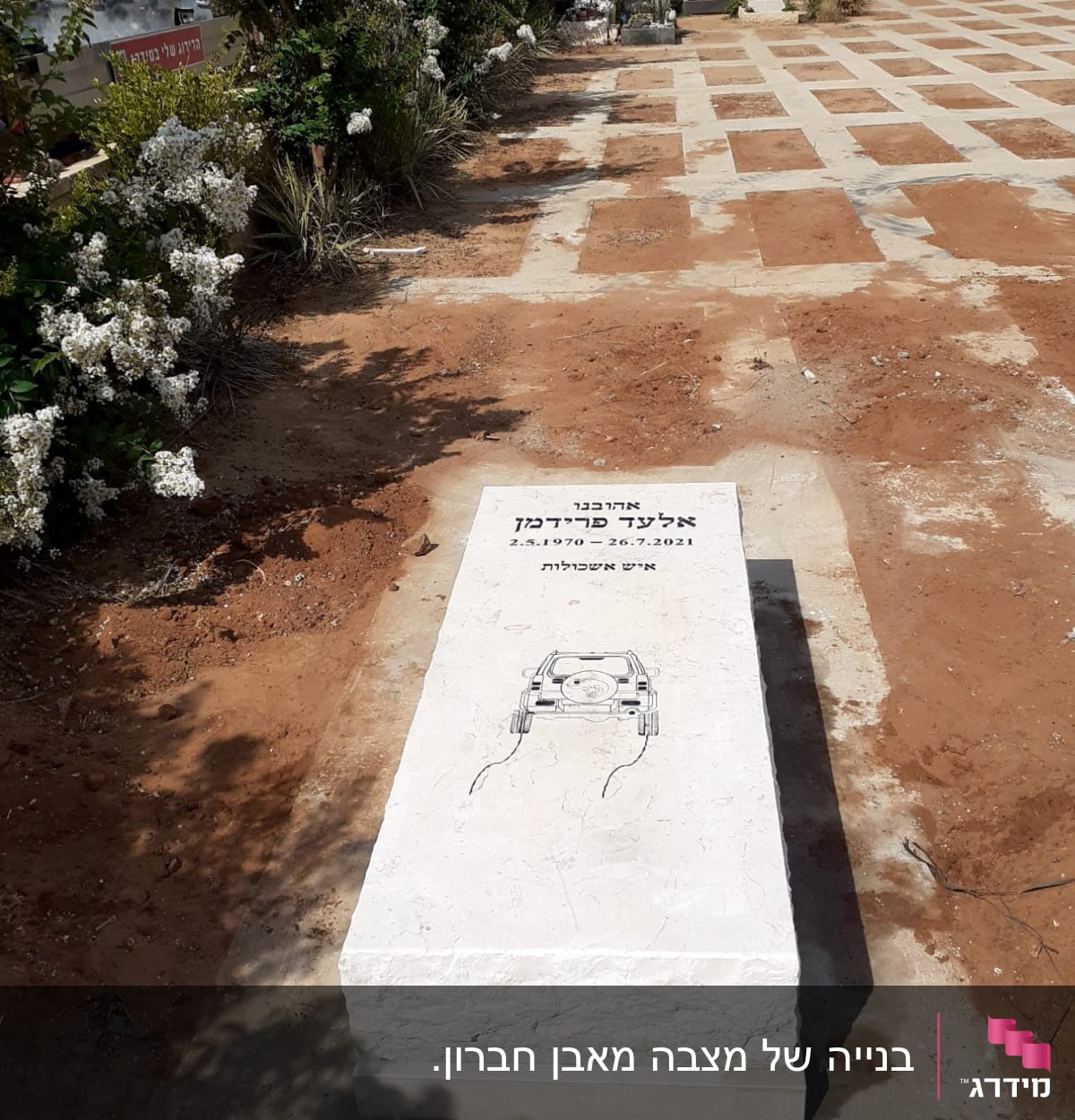 מצבה לבנה עם כיתוב וציור של רכב